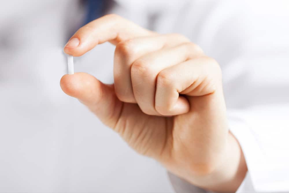 Doctor holding a hormone replacement pill. Often used for hormone replacement therapy.